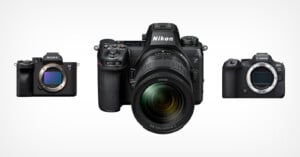 Three digital cameras are displayed against a white background. From left to right, they are a Sony Alpha model, a Nikon Z model, and a Canon EOS model. Each camera has a prominent lens mount or attached lens, showing part of their front designs.