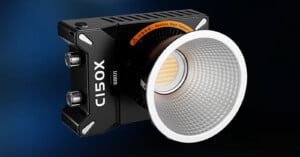 A close-up of a modern LED studio light labeled "C150X" with the brand name "Sirui". The light features a cylindrical, textured reflector attached to a rectangular body, with two control knobs on the side. The background is dark blue, highlighting the light.