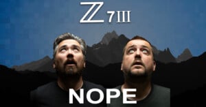 Two men with surprised expressions look upwards against a backdrop featuring a mountain range silhouette and a pixelated blue sky. Above them, large text reads "Z 7III." Below them, the word "NOPE" is displayed in bold white letters.