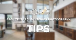 Blurry image of a modern kitchen and living area, with white text overlay reading "TOP 5 ARCHITECTURAL & INTERIOR PHOTOGRAPHY TIPS." The room features a mix of wood and white elements, large windows, and contemporary furnishings.