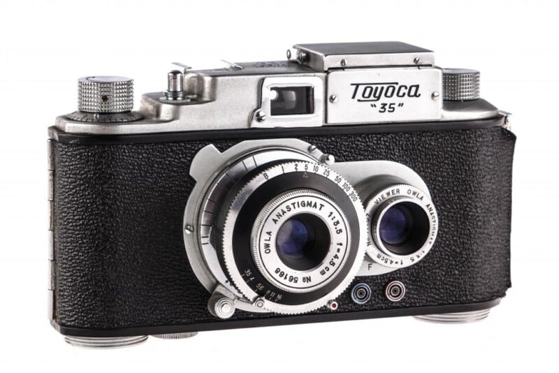 A vintage Toyoca 35 camera with a silver metal body and black textured grip. The lens has markings "Owl Anastigmat 1:3.5 F=5 CM." The camera features various dials and buttons, including a winding knob and lens adjustment rings.