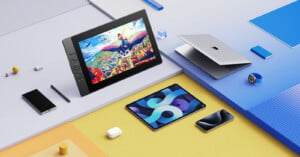 A top-view image of various tech gadgets on a colorful, geometric surface. Visible items include a laptop, a tablet displaying a vibrant animation, a smartphone, an Apple Watch, and a stylus. The background has sections in blue, yellow, and orange shades.