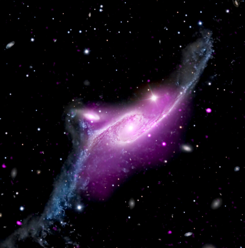 A vibrant image of a galaxy against the backdrop of space. The galaxy is highlighted in bright pink and purple hues, with a bright core and sprawling arms. Surrounding it are numerous stars and other distant galaxies, creating a mysterious and awe-inspiring scene.