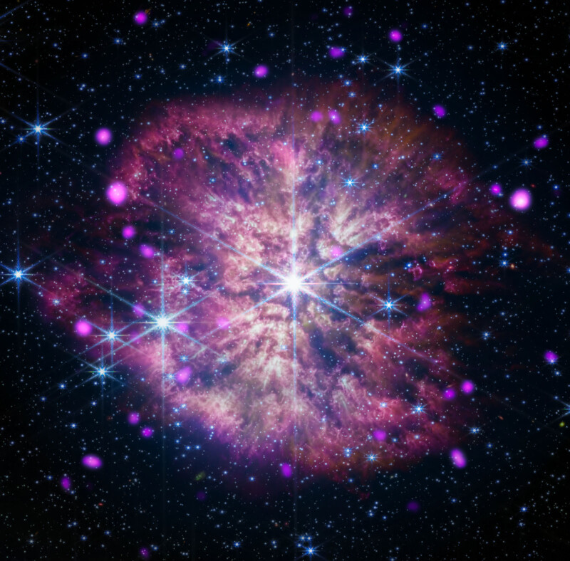 A vibrant image of a star field featuring a luminous Wolf-Rayet star surrounded by a bright, purplish-red nebula. The star radiates intense light, casting a majestic glow amid numerous smaller, twinkling stars scattered across the dark, starry background.