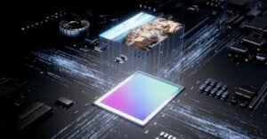 A digital rendering of a computer chip with various electronic components. The chip is illuminated with light trails representing data transfer, and a small, pixelated image of a landscape hovers above the chip, symbolizing processing power and digital imaging.