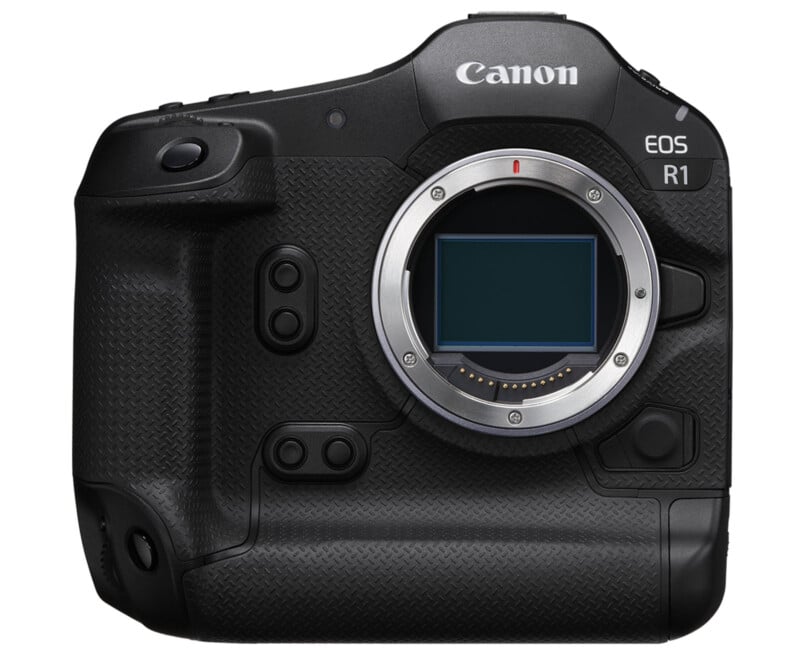 A Canon EOS R1 camera body with a black textured grip, prominent buttons, and a silver lens mount with no lens attached. The camera has a sleek and robust design, suitable for professional photography use.