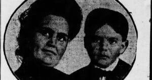 A black and white image shows a close-up of two individuals, a woman on the left and a child on the right. The woman has dark, voluminous hair and the child has short, neatly combed hair. Both individuals are dressed in formal clothing.