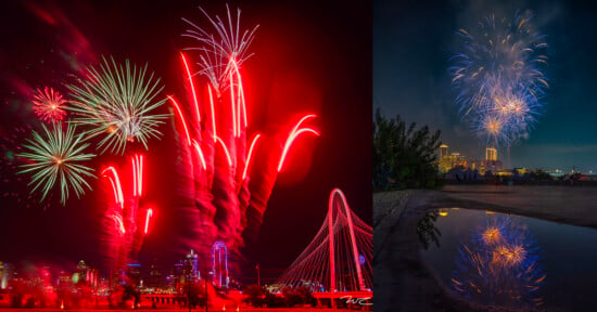 A vibrant fireworks display in a city skyline. On the left, multicolored fireworks illuminate a bridge and buildings with emphasis on red trails. On the right, blue and white fireworks burst against the night sky, reflected on a wet surface below.