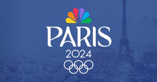 A logo for the Paris 2024 Olympics is displayed, featuring the Olympic rings and the NBC peacock logo above the word "Paris." The Eiffel Tower and a view of Paris are visible in the background. The color scheme is predominantly blue.