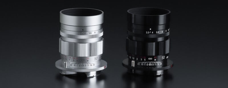 Two camera lenses, one silver and one black, are displayed side by side on a dark surface. Both lenses feature various aperture and focus markings in white and red, with ridged adjustment rings for ease of handling and precise adjustments.