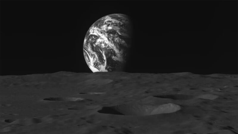 A view of Earth from the Moon in black and white. The foreground shows the rugged, cratered surface of the Moon, while the Earth appears partially illuminated in the background, with its distinctive landmasses and clouds visible.