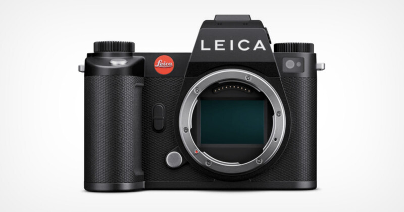 A black Leica mirrorless digital camera without a lens attached is shown. The brand name "LEICA" is prominently displayed at the top, and the camera's sensor is visible in the central mount area. The camera has a textured grip on the left side.