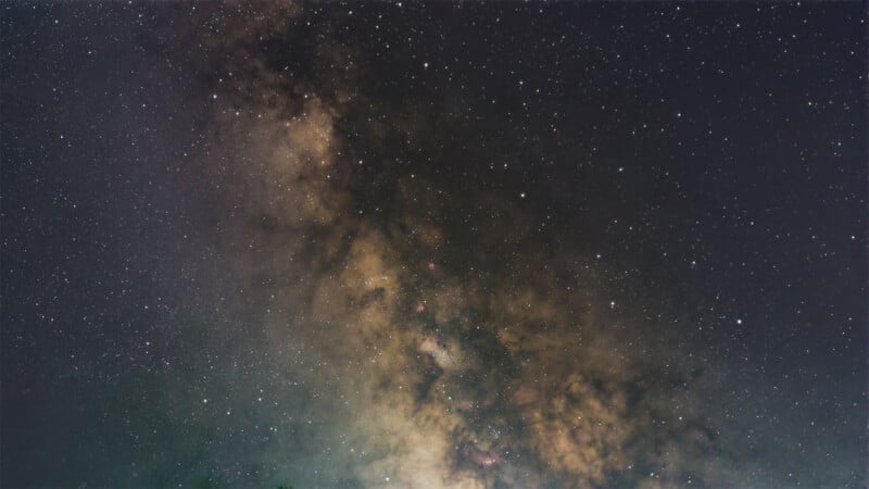 A stunning view of the Milky Way galaxy stretching across the night sky. The image captures the densely packed stars and cosmic dust, creating a beautiful and intricate pattern of light and dark areas in the vast expanse of space.