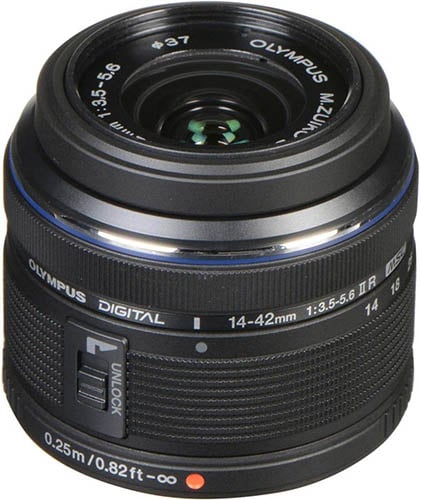 A close-up view of an Olympus M.Zuiko Digital 14-42mm f/3.5-5.6 II R camera lens. The lens is black with a textured grip and detailed markings, including focal lengths and aperture ranges. There is also an unlock switch and some branding on the lens.