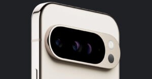 Close-up of a smartphone's rear camera module. The phone features a sleek, light-colored design with a metallic frame. The camera module contains three lenses, a flash, and another sensor arranged horizontally in a black, oval-shaped enclosure.
