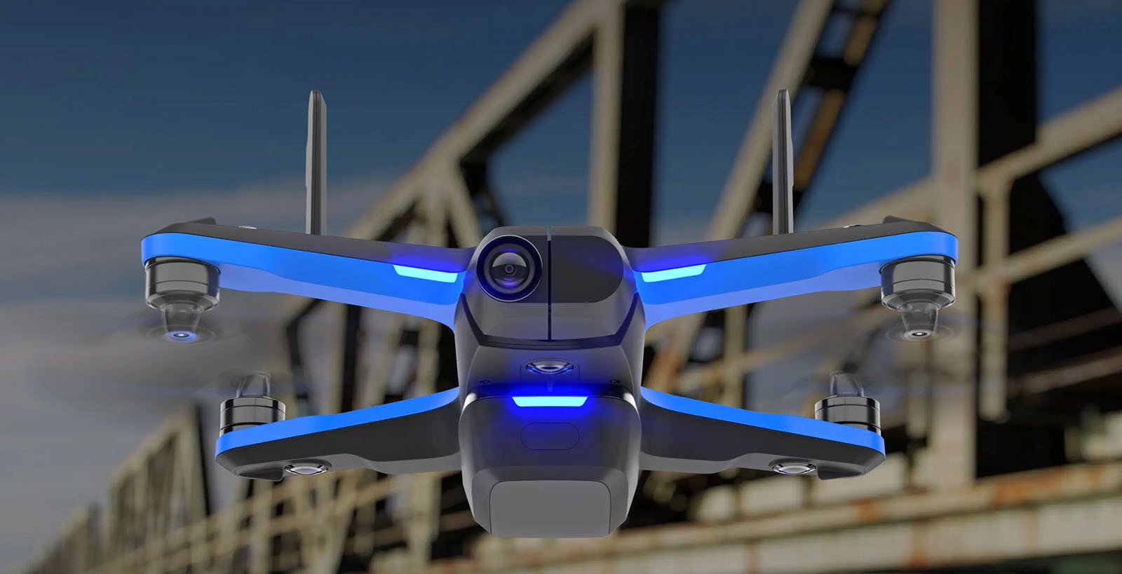 A futuristic drone with blue LED lights hovers in the air. The drone has a sleek design with four propellers and a camera in the front. The background features the structure of a bridge and a clear blue sky.