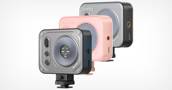 The image displays three SmallRig camera lighting devices in different colors (gray, pink, and black). Each has a round light panel with a small screen showing settings. They are compact, rectangular, and mounted on a standard camera accessory base.