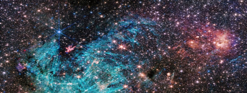 An image of a star-filled galaxy with dense clusters of stars. A prominent blue nebula appears in the center left, featuring intricate shapes and streaks. To the right, there's a reddish-orange area with a cloudy, fiery appearance. The background is deep space black.