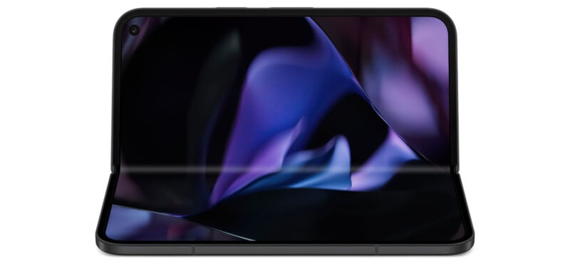 A foldable smartphone is partially opened, displaying a colorful, abstract background on its screen. The device has a camera notch on the top left corner and a hinge in the middle allowing it to fold. The colors on the screen are predominantly dark with shades of purple.