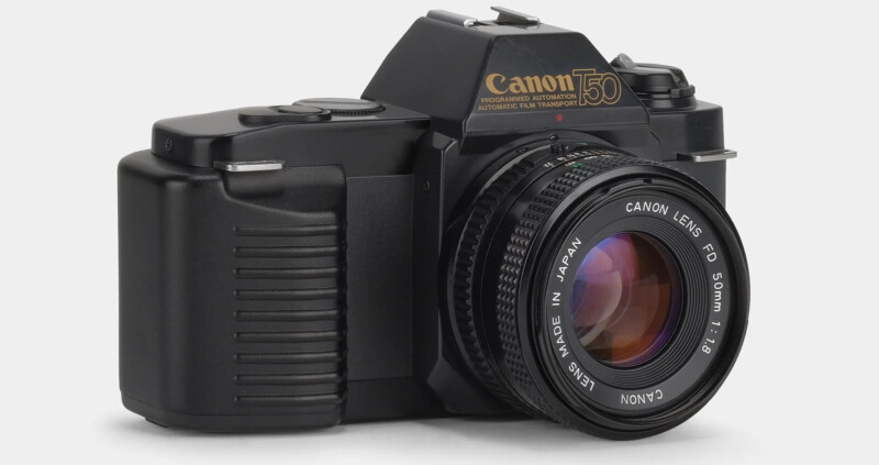 A Canon T50 35mm film SLR camera is displayed in a three-quarter view. It features a Canon Lens FD 50mm 1:1.8 lens. The camera has a black body and a textured grip on the right side. The camera's branding and model details are visible on the pentaprism housing.