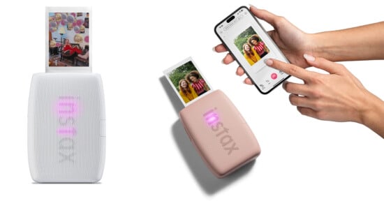 The image shows a wireless portable photo printer producing an instant photo. To the right, a smartphone is connected, displaying a photo being sent for printing. There are two printers - one white and one pink, with the pink printer actively printing a photo.