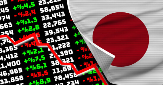 A torn Japanese flag reveals a stock market board filled with numbers, indicating both positive and negative percentages. A red graph line descending sharply represents a downturn in the market. The juxtaposition suggests financial issues affecting Japan's economy.