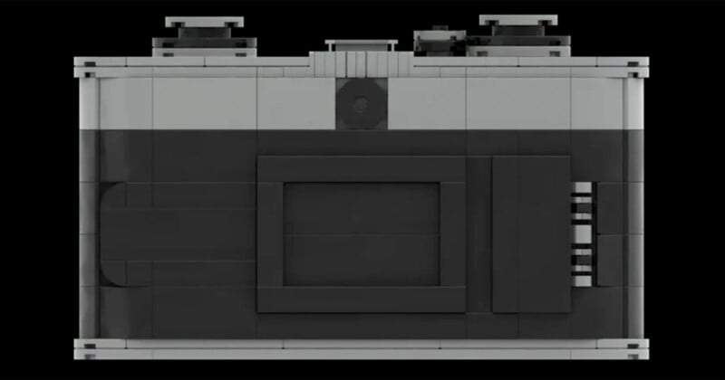 A LEGO model of a camera viewed from behind. The model features a black and gray color scheme, a central screen as the camera's display, and several buttons and controls on the top. The overall design mimics the shape and layout of a traditional camera.