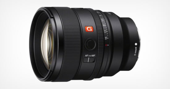 A black camera lens with a wide front glass element. The lens features a red "G" logo, focus mode switch labeled "AF/MF," and aperture ring with marked f-stops. The lens mount is labeled "E mount.