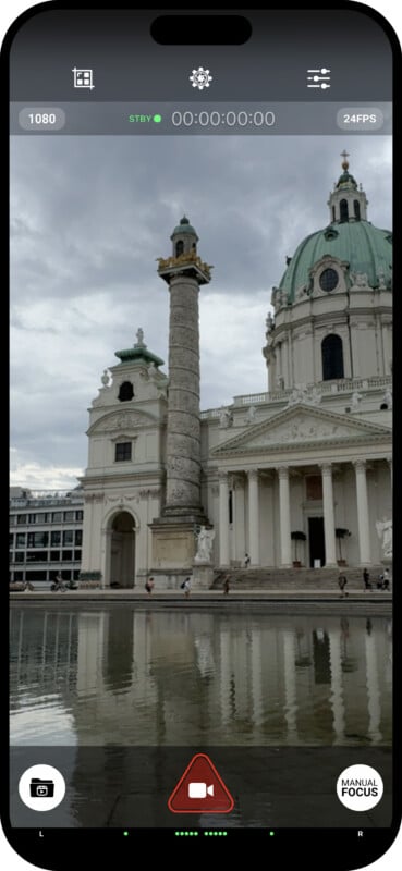 A smartphone screen displaying a camera app interface capturing a large historic building with classical architecture. The building has a prominent column and dome, and is reflected in a body of water in the foreground. Various camera controls and settings are visible.