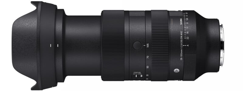 A black Sigma 28-70mm F2.8 DG DN Art lens lying horizontally. The lens has a wide zoom ring, focus ring, and an aperture ring with markings from f/2.8 to f/22. A lens hood is attached to the front.