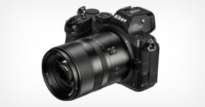 A Nikon Z7 mirrorless digital camera with a large lens attached, featuring various control buttons and a comfortable grip. The camera body appears black with a matte finish, designed for professional photography. The background is plain white.