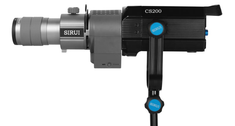 A side view of a black and gray Sirui CS200 professional camera mounted on a stand. The camera has a large lens on the left and a ribbed body with blue accents and a branded nameplate.