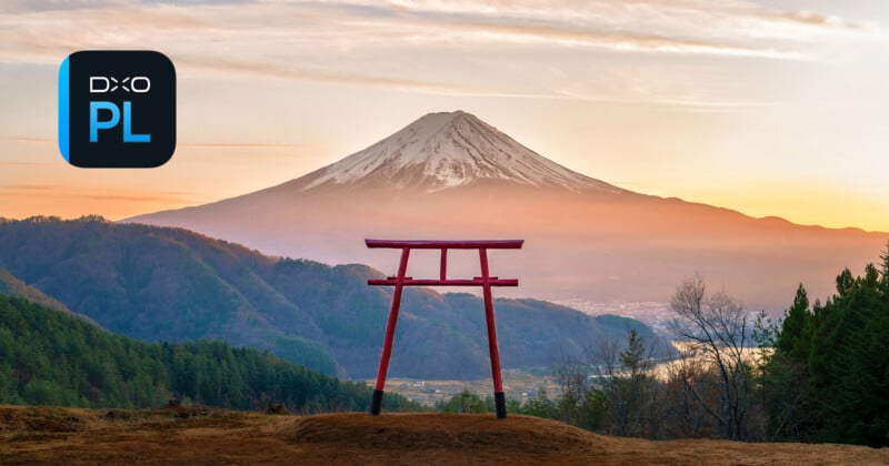 A majestic scene featuring a traditional red torii gate in the foreground overlooking a lush valley, with the snow-capped peak of Mount Fuji dominating the background under a pastel-colored sky. The DxO PL logo is placed in the top left corner.