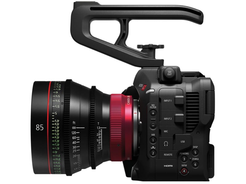 Side view of a professional video camera with a large, wide-angle lens and various control buttons. The camera features a prominent handle on top and is equipped with multiple inputs and settings for precise adjustments. The lens has an 85mm focal length marking.