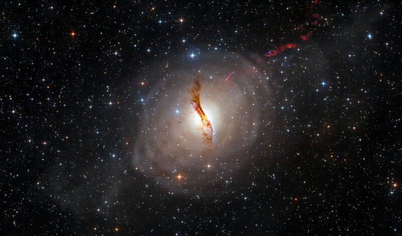 A high-resolution image of a galaxy known as Centaurus A, with a bright core surrounded by a dark dust lane. Bright stars are scattered across the background, and there are jets of red light emanating from the galaxy's center.