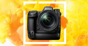 The image shows a Nikon DSLR camera with a large lens against a vibrant yellow and orange abstract background. The camera features multiple buttons and dials, and the brand name "Nikon" is visible on the upper portion near the viewfinder.