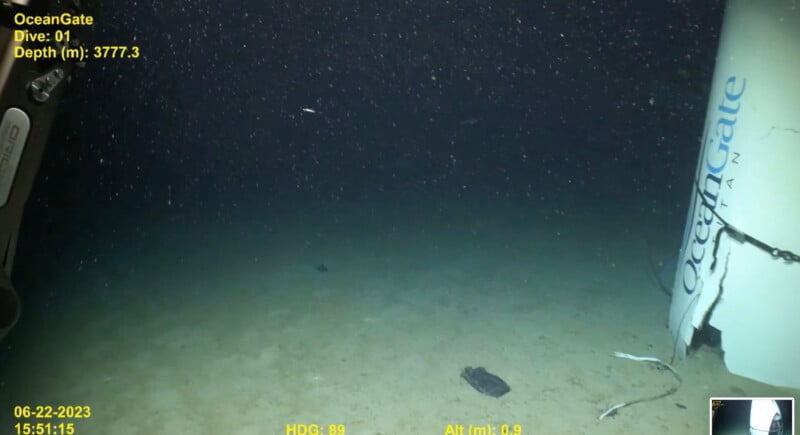 A deep-sea view shows the ocean floor with a few scattered objects at a depth of 3777.3 meters. Text in the image includes "OceanGate," "Dive: 01," and the date "06-22-2023." Other displayed metrics include heading, altitude, and timestamp.