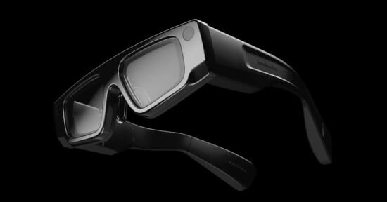 Close-up image of sleek, black augmented reality (AR) glasses with a minimalist design, set against a black background. The glasses feature thick frames and a modern, high-tech appearance, highlighting their potential for advanced AR functionalities.