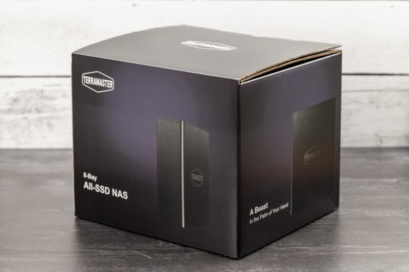 A black Terramaster box with white text is displayed on a wooden surface. The box is labeled "8-Bay All-SSD NAS" and features images of the product along with the Terramaster logo.