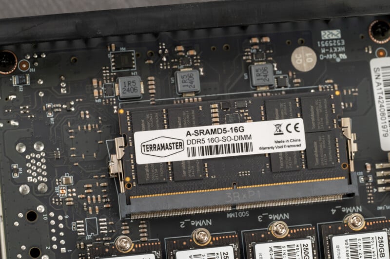 Close-up of a computer motherboard with a Terramaster 16GB DDR5 SO-DIMM RAM module installed in the slot. Various electronic components and circuit paths are visible on the motherboard around the RAM module.