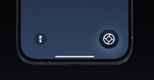 Close-up of the bottom part of a smartphone screen showing the flashlight icon on the left and the camera icon on the right, set against a dark background. The icons are illuminated, indicating their active status.