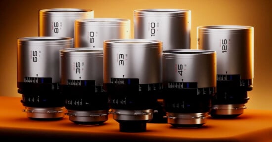 A collection of eight professional camera lenses of varying focal lengths is displayed against a warm, gradient orange background. The lenses are metallic with black rings and are neatly arranged, showing different focal length markings such as 3.6, 4.6, 6, 8.5, 10, 12.5, 16, and 25 mm.