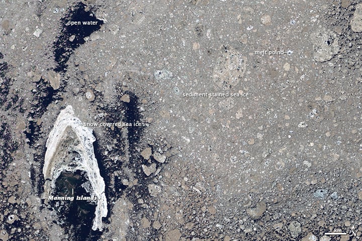 A satellite image captures a frozen Arctic region featuring Nansen Island surrounded by snow-covered sea ice. The area shows patches of sediment-stained sea ice, melt ponds, and open water, all labeled for reference. A scale bar indicates the size of the area.