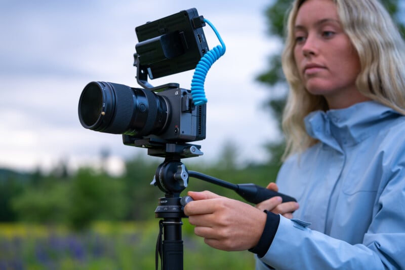 woman using a camera mounted to a monopod