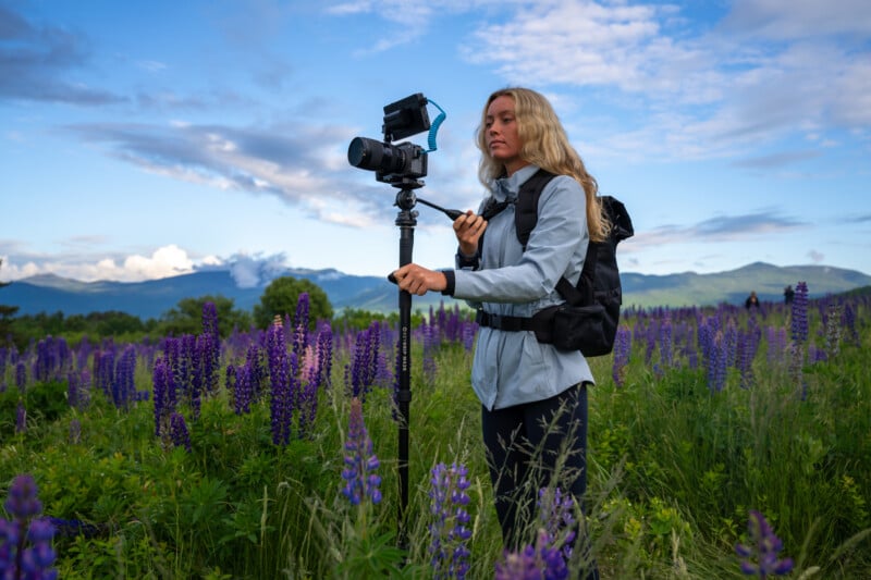 woman using a camera mounted to a monopod