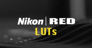 The image displays a promotional graphic with the text "Nikon RED LUTs" in bold, white letters. The background is blurred with dark, wavy patterns, focusing attention on the text.