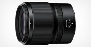 A black NIKKOR 50mm f/1.4 camera lens is shown against a plain white background. The lens features detailed ridges for grip and clear labeling of its specifications.