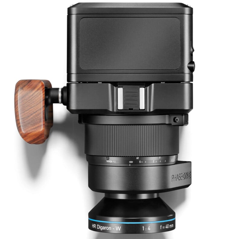 A high-resolution camera with a sleek black finish, featuring a wooden side handle and lens marked "HR Digaron - W 1:4 f=40 mm PHASE ONE." The lens includes a focus ring with detailed distance markings and a robust mount system.