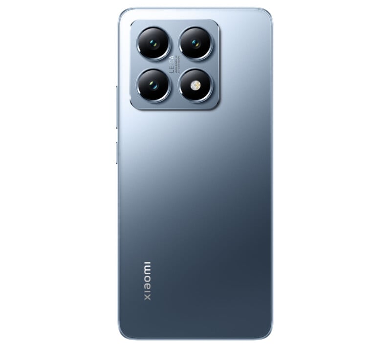 A sleek, silver smartphone is shown from the back. It features four rear cameras arranged in a square module at the top left corner. The brand name "Xiaomi" is printed vertically at the bottom left of the phone. The design is minimalist and modern.