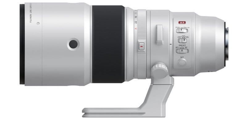 A high-quality telephoto camera lens with a silver finish and black focus ring. It features various switches and a tripod mount. The lens is oriented horizontally, showcasing its detailed design and craftsmanship.